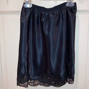 Black half slip with walking slit. Bordered with lace. Victoria’s Secret.